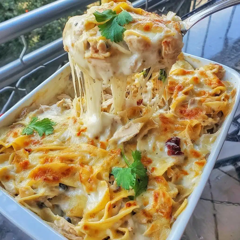 Creamy chicken noodle casserole dish ready to serve, garnished with herbs.