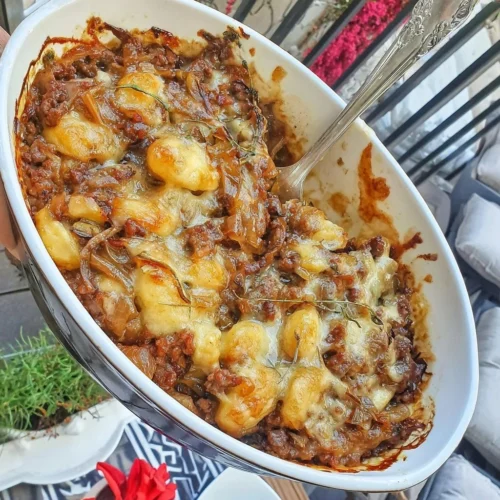 Beef casserole with ground beef and caramelized onions in a rustic dish.