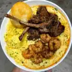 Jalapeno cheddar grits with Cajun honey butter lamb chops and shrimp with cheesy eggs and a buttermilk biscuit