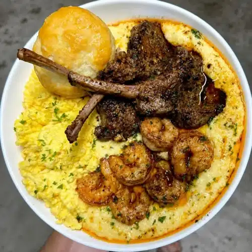 Delicious plate of jalapeno cheddar grits with Cajun honey butter lamb chops and shrimp.